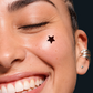 Persona mostrando un parche hidrocoloide para granos Stiq Patches Starwear con forma de estrella negra  (noir)